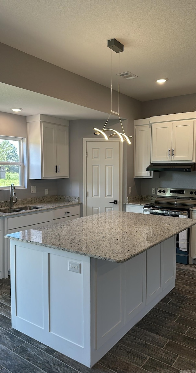 kitchen featuring white cabinetry, stainless steel range with electric stovetop, decorative light fixtures, a kitchen island, and light stone countertops