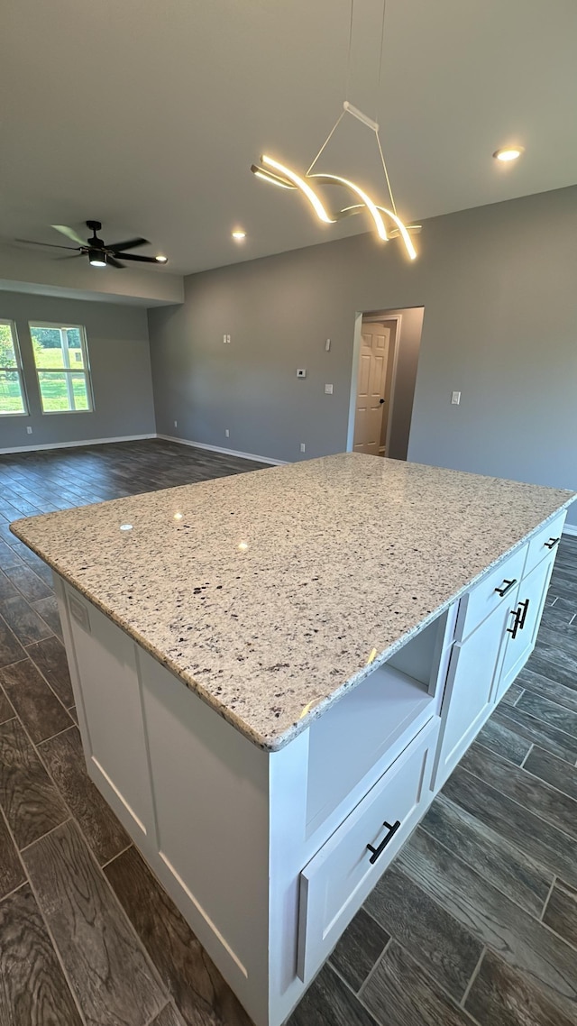 kitchen featuring white cabinetry, decorative light fixtures, and light stone countertops