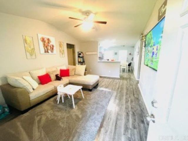 living room with hardwood / wood-style flooring, vaulted ceiling, and ceiling fan