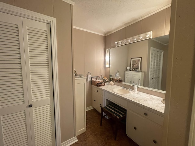 bathroom featuring ornamental molding, vanity, and a textured ceiling