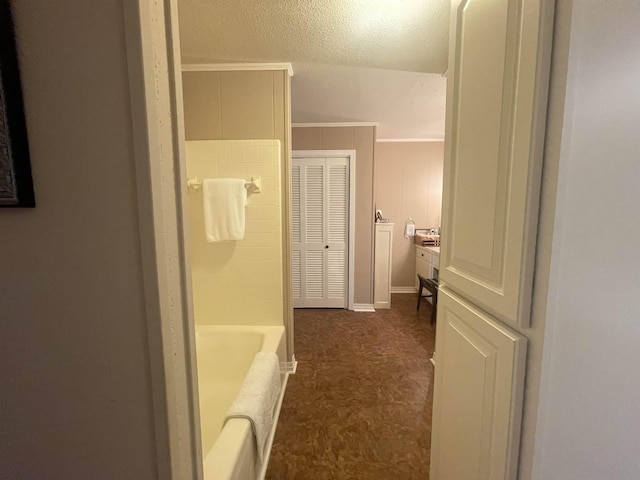 bathroom with ornamental molding and a tub to relax in