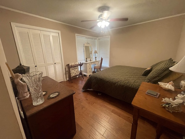 bedroom featuring hardwood / wood-style floors, ceiling fan, crown molding, a textured ceiling, and a closet