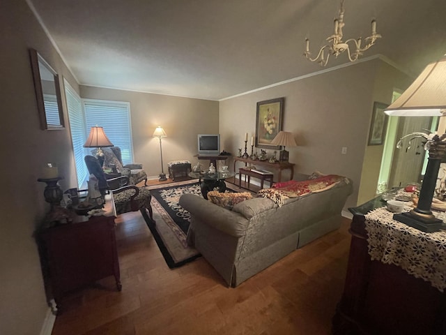 living room with wood-type flooring, ornamental molding, and a notable chandelier