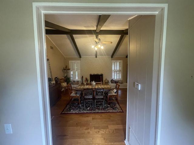 dining space featuring lofted ceiling with beams, hardwood / wood-style floors, and ceiling fan