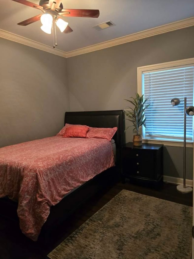 bedroom with ornamental molding, ceiling fan, and dark hardwood / wood-style flooring