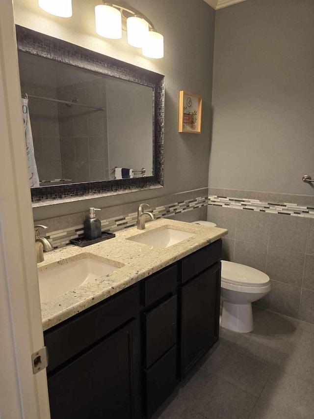 bathroom with tile patterned floors, toilet, vanity, and tile walls