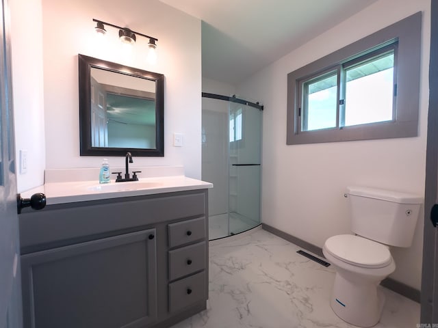 bathroom with vanity, toilet, and a shower with door