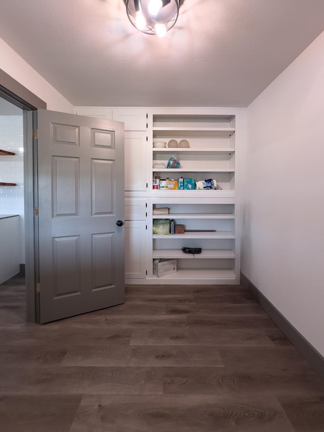 hallway with dark wood-type flooring and a textured ceiling