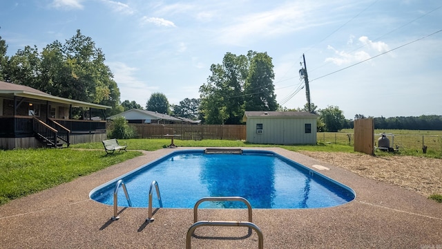 view of pool featuring a lawn and a shed