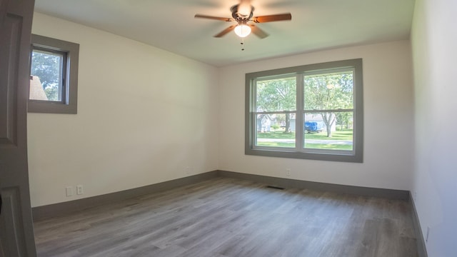 spare room featuring dark wood-type flooring and ceiling fan