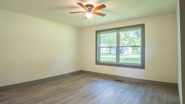 spare room with ceiling fan and light wood-type flooring