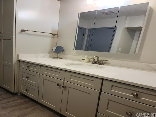 bathroom with vanity, a textured ceiling, and hardwood / wood-style flooring