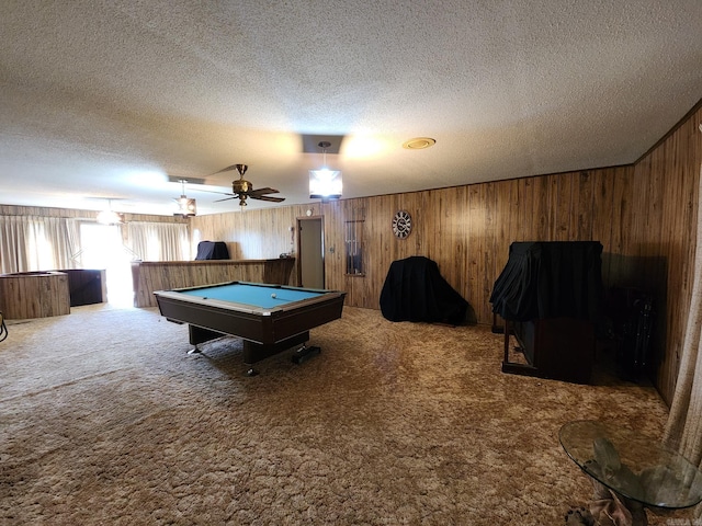 game room with wooden walls, a textured ceiling, pool table, ceiling fan, and carpet floors