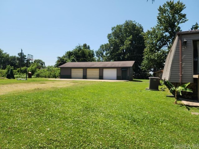 view of yard with a garage, an outbuilding, and cooling unit