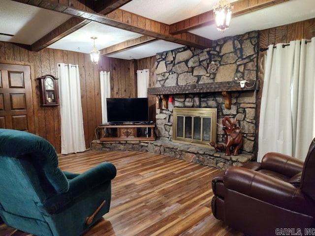 living room with wood walls, hardwood / wood-style flooring, a fireplace, and beamed ceiling