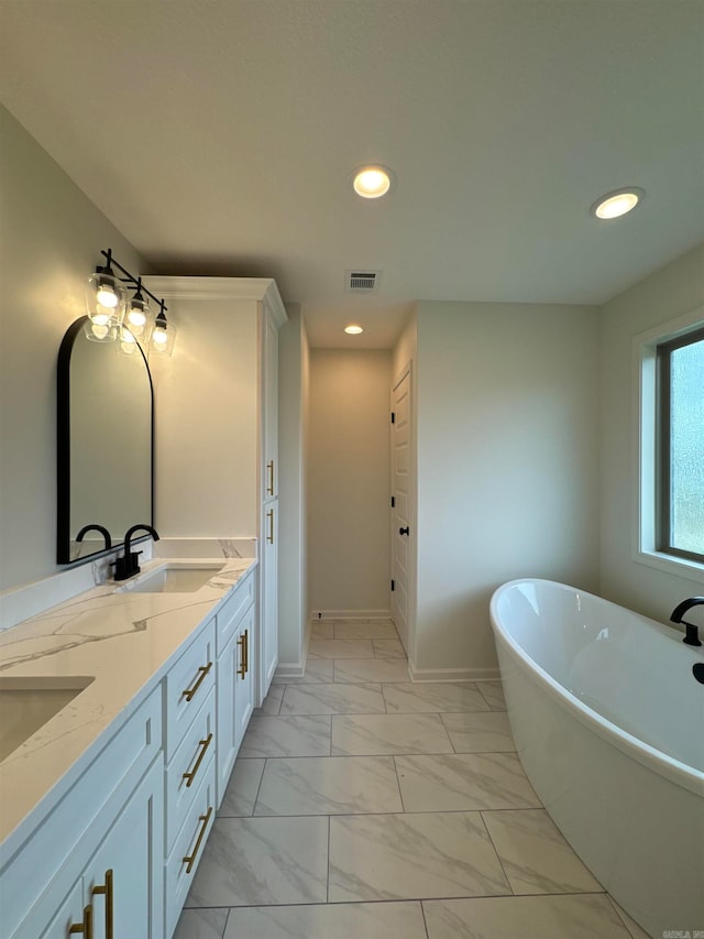 bathroom featuring tile patterned flooring, dual vanity, and a tub to relax in