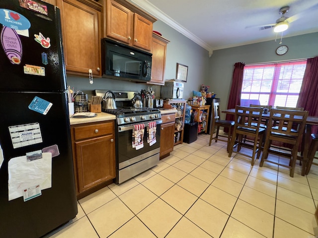 kitchen featuring brown cabinetry, light countertops, crown molding, black appliances, and light tile patterned flooring