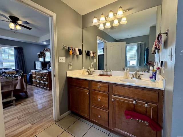 ensuite bathroom with a sink, ceiling fan, double vanity, and connected bathroom