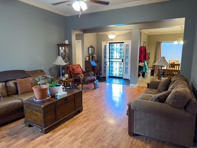 living room with ornamental molding, ceiling fan, and light hardwood / wood-style floors