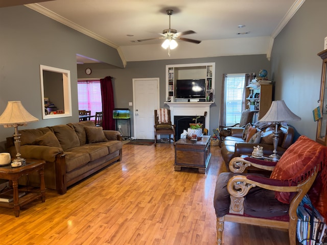 living room with a fireplace, light wood finished floors, visible vents, ornamental molding, and a ceiling fan