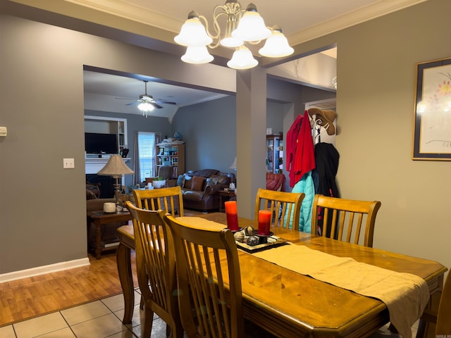 dining room with ornamental molding, tile patterned floors, baseboards, and ceiling fan with notable chandelier