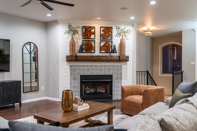 living room featuring ceiling fan, a fireplace, and hardwood / wood-style floors