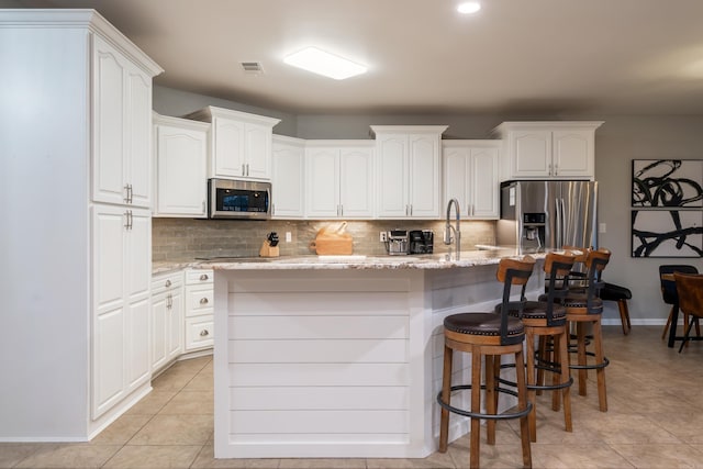 kitchen with white cabinetry, appliances with stainless steel finishes, and a center island with sink