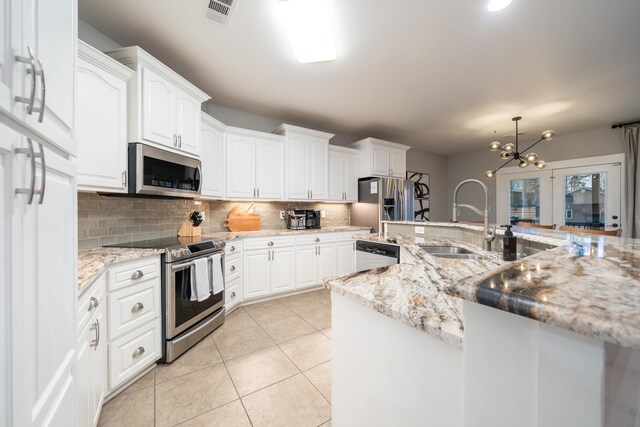 kitchen with appliances with stainless steel finishes, light stone countertops, sink, and white cabinets