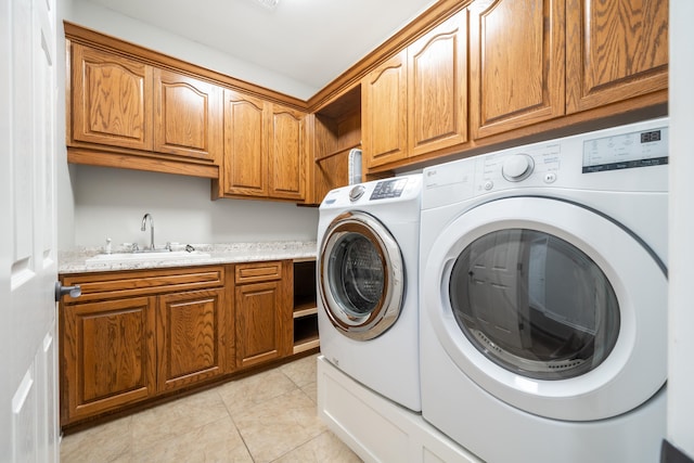 washroom with cabinets, washing machine and dryer, sink, and light tile patterned floors