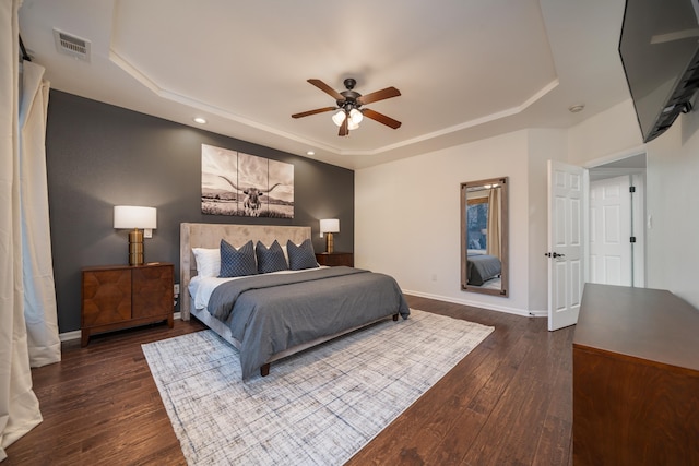 bedroom featuring ceiling fan, dark hardwood / wood-style floors, and a raised ceiling