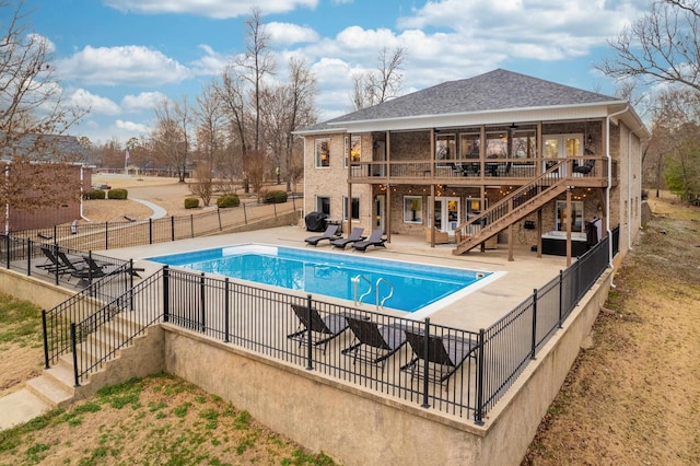 view of swimming pool featuring a wooden deck, a sunroom, and a patio