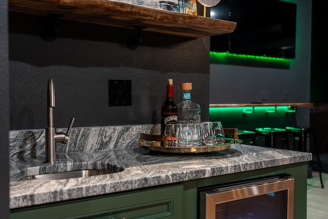 bar with sink, beverage cooler, and green cabinetry