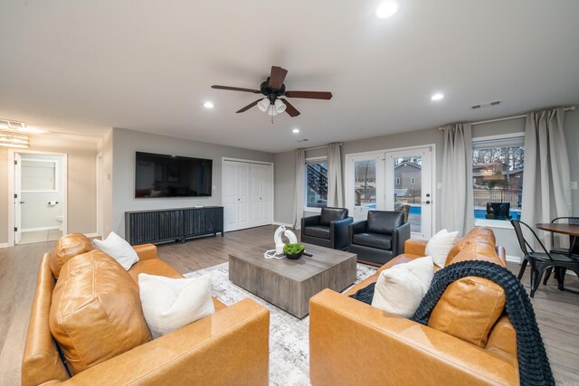 living room featuring ceiling fan and light hardwood / wood-style floors