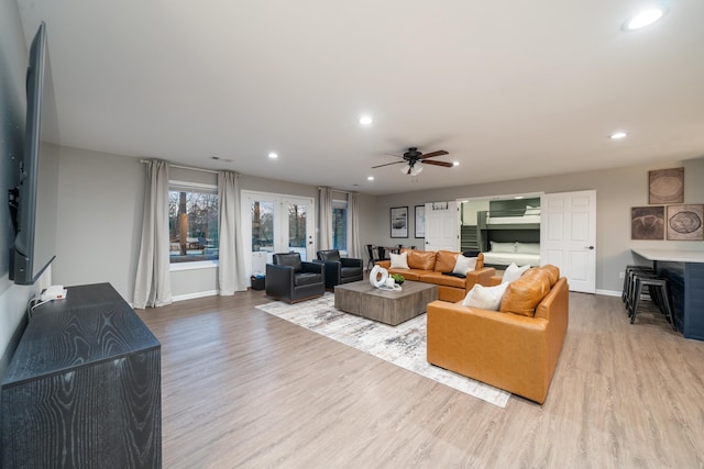 living room featuring ceiling fan, light wood-type flooring, and french doors