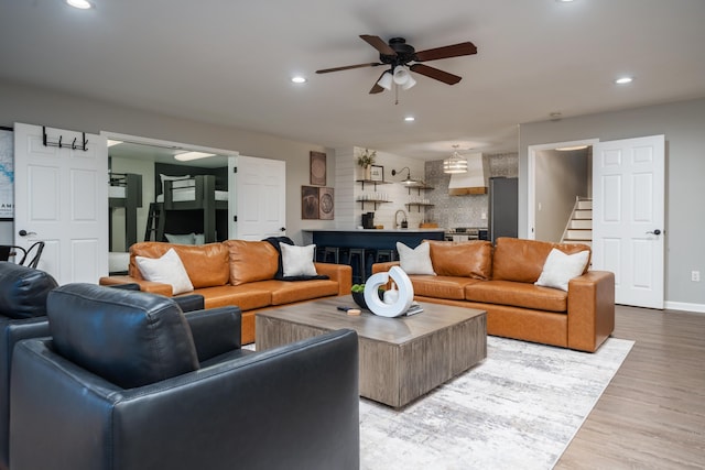 living room featuring sink, light hardwood / wood-style flooring, and ceiling fan