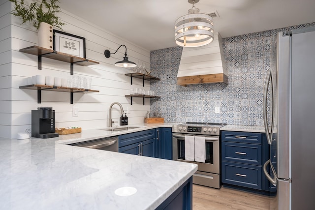 kitchen with blue cabinetry, stainless steel appliances, sink, and custom exhaust hood