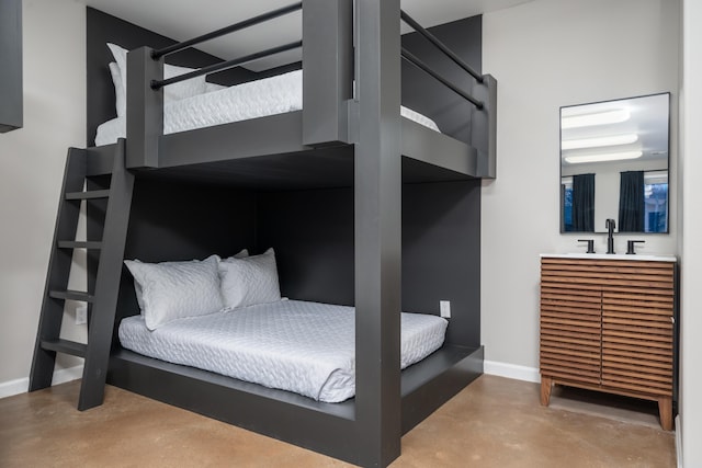 bedroom featuring concrete flooring and sink