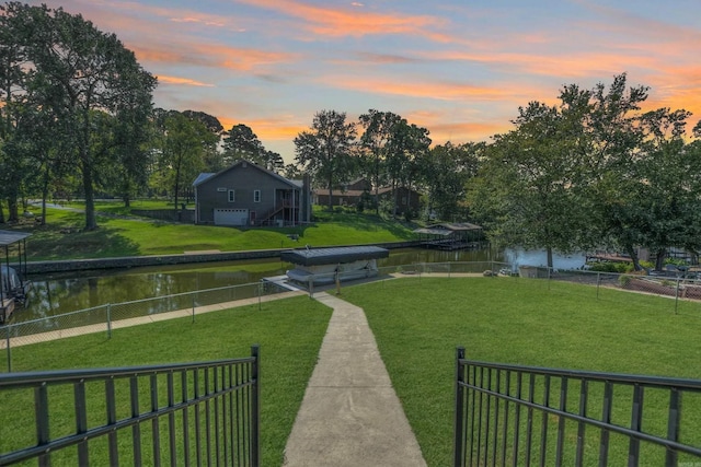 surrounding community with a water view and a yard