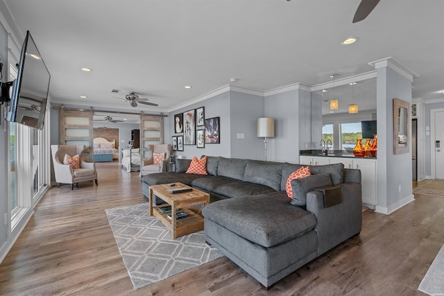 living area featuring a barn door, wood finished floors, a ceiling fan, and recessed lighting