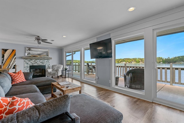 living area featuring ceiling fan, ornamental molding, wood finished floors, a fireplace, and recessed lighting