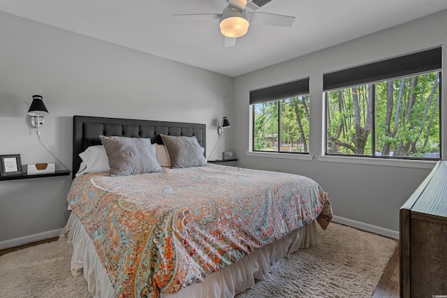 bedroom with a ceiling fan, light wood finished floors, and baseboards