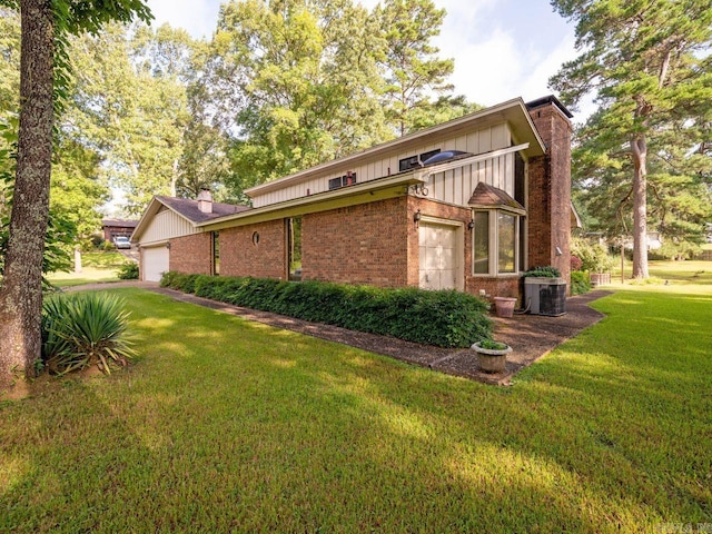 view of home's exterior with central air condition unit, a garage, and a yard