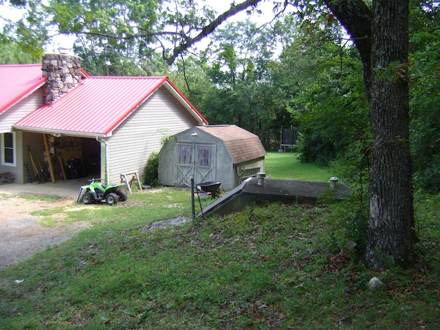 view of side of property featuring a yard and a storage unit