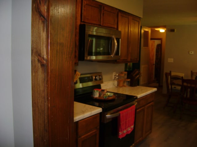 kitchen featuring stainless steel appliances and dark hardwood / wood-style flooring