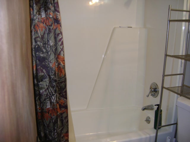 bathroom with toilet and shower / bathtub combination with curtain