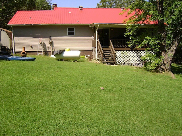 back of property with a yard and a deck