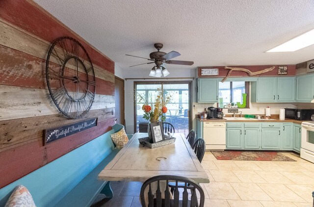 kitchen with light tile patterned flooring, white appliances, a textured ceiling, ceiling fan, and sink