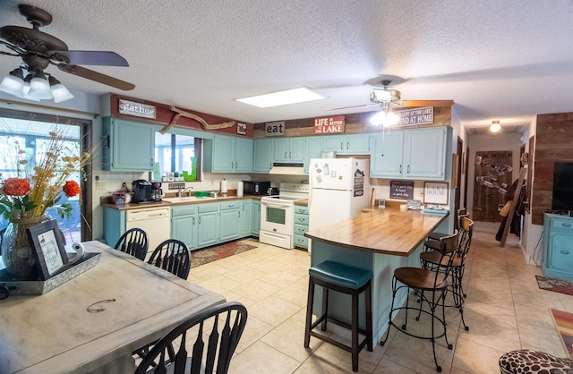 kitchen featuring wooden counters, ceiling fan, white appliances, and light tile patterned floors