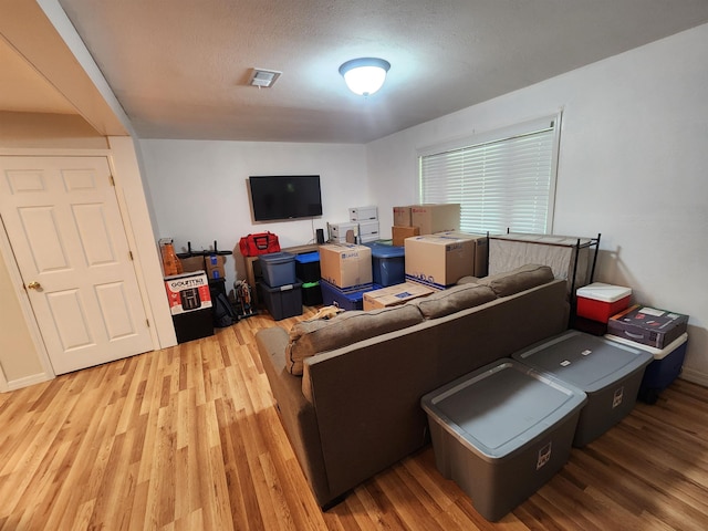 living room featuring a textured ceiling and light hardwood / wood-style flooring