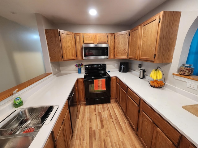 kitchen featuring sink, black appliances, and light hardwood / wood-style floors